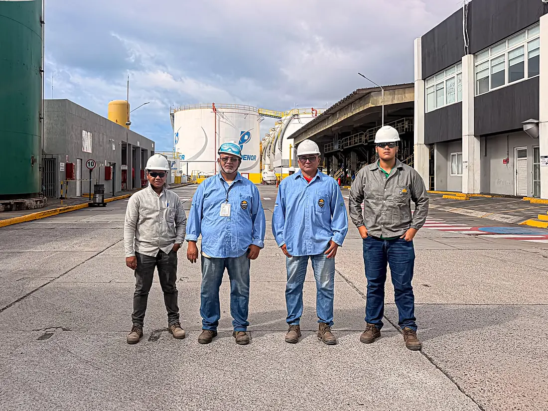 Equipe de gestão da JRP de capacete, em pé no pátio de um terminal de tanques no Porto de Suape