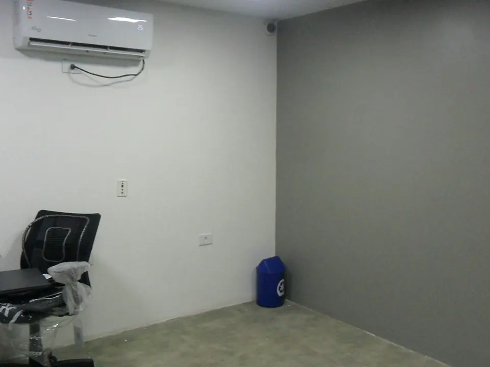 Sala administrativa com paredes emassadas e pintadas em branco e cinza